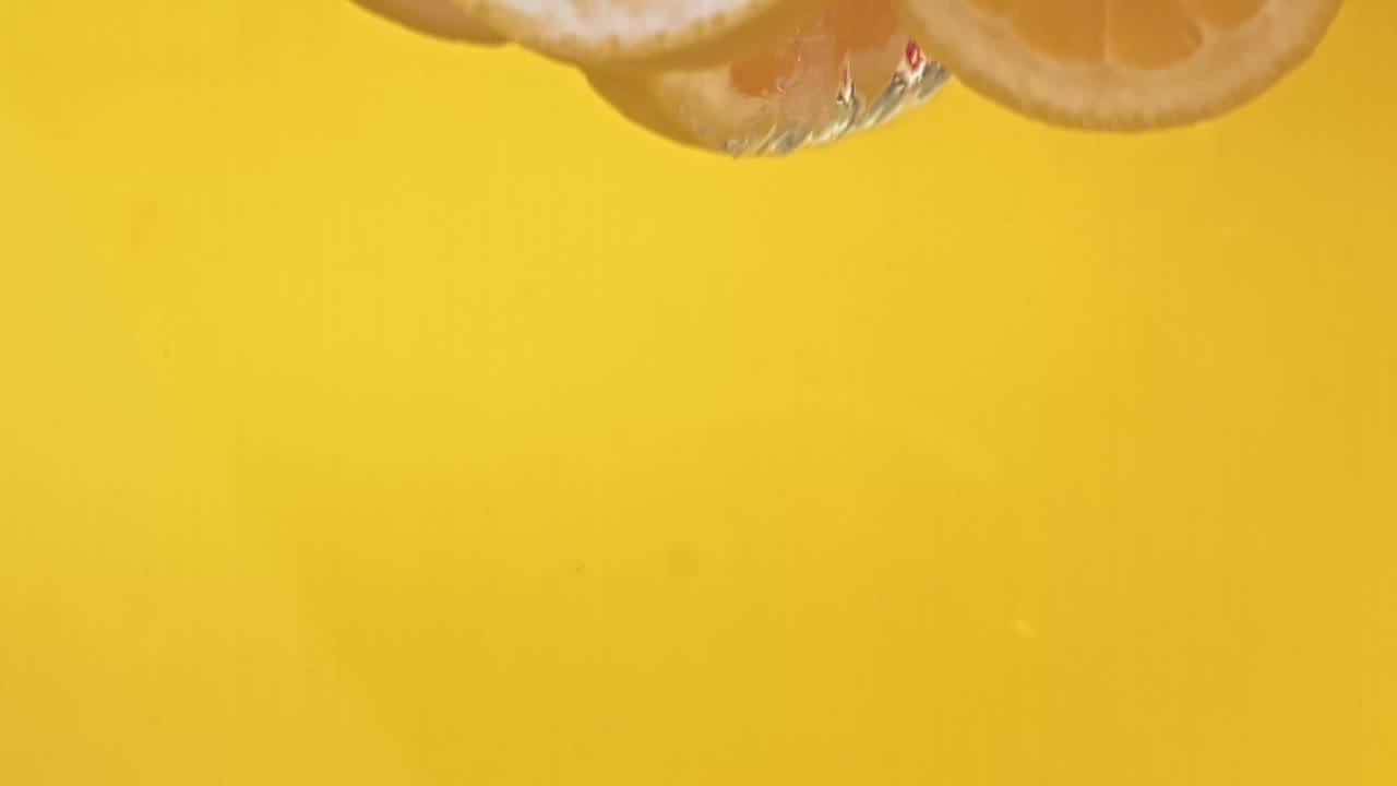 Lemon Slices Splashing Into Water.