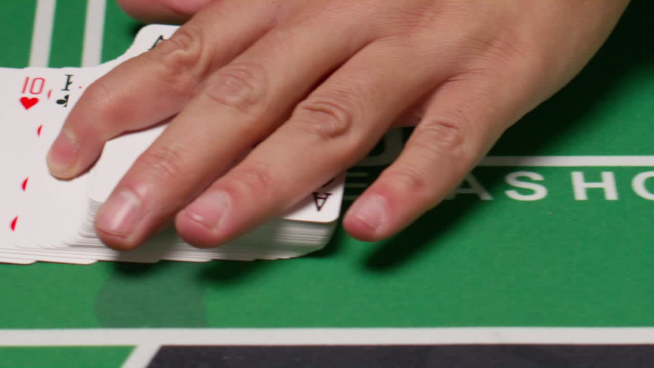 Playing cards spread on a green table with a hand pointing - Free Stock ...