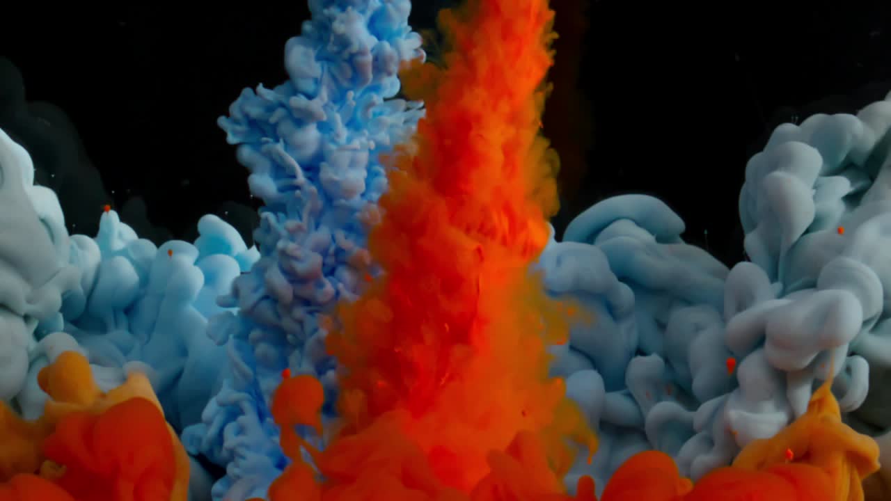 Vibrant colored inks interacting with a black liquid creating flowing ...