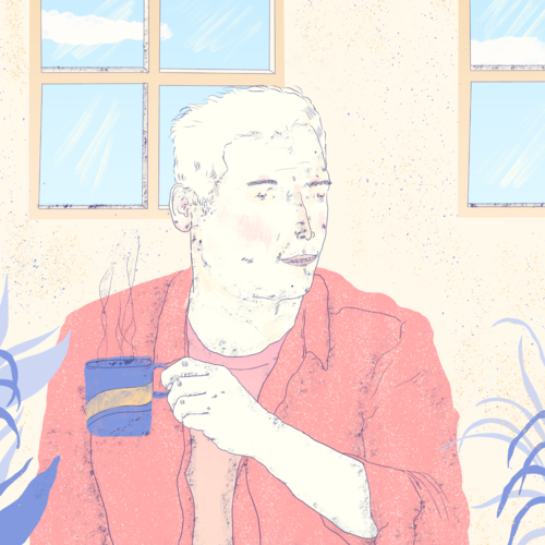 Young man sitting at a table drinking a mug of coffee
