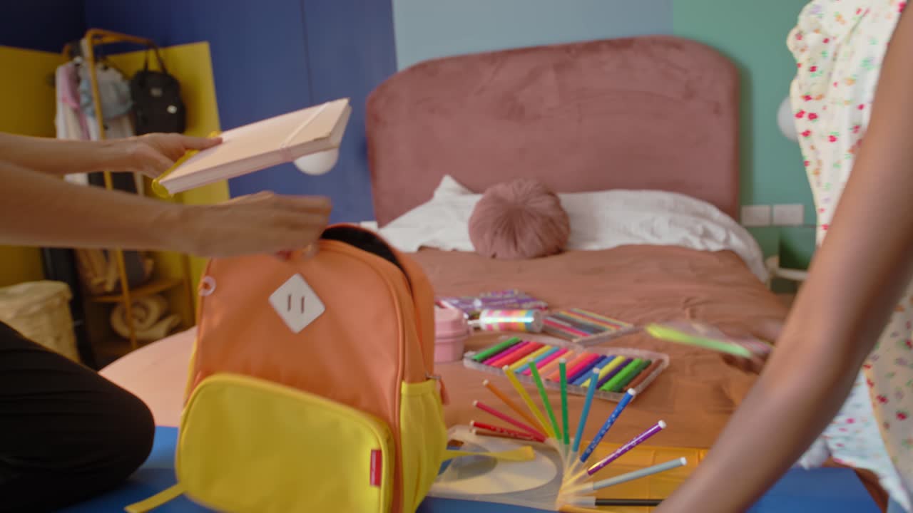 Mom and Daughter Packing School Supplies .