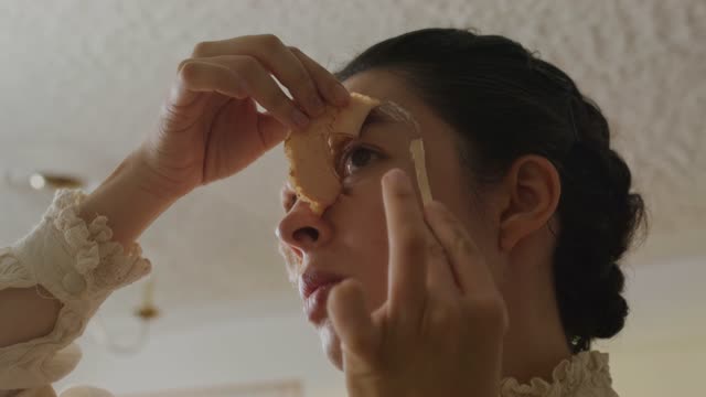 Woman Applying Prosthetics for Monster Look.
