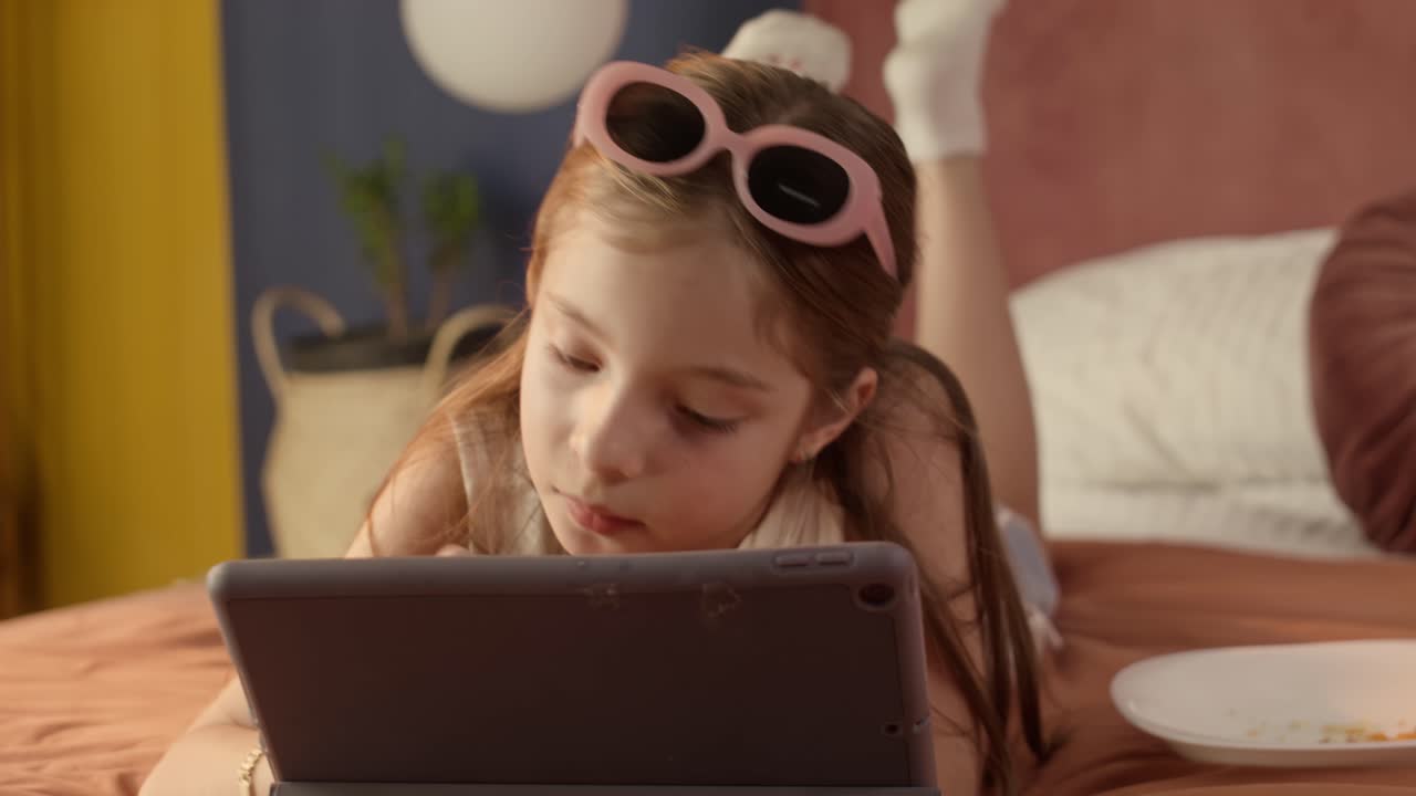 Girl Coloring on Tablet in Bed.