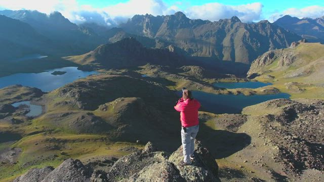 Photographer working at the top of a mountain peak.