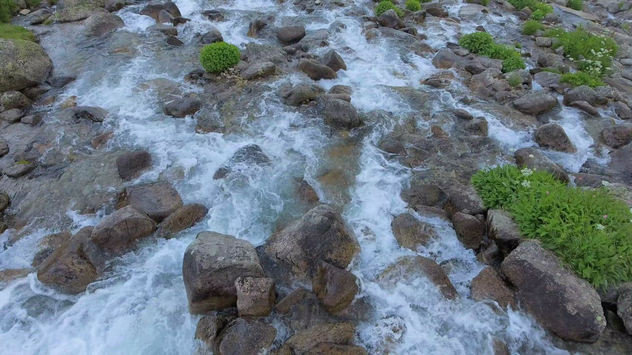Flying over a stream with rocks - Free Stock Video