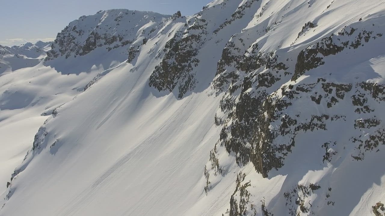 Flying through a snowy mountain with rocks - Free Stock Video