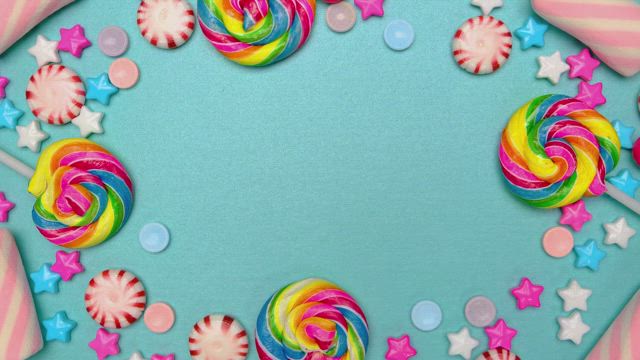 Frame of candies, lollipops and chocolates on a blue background.