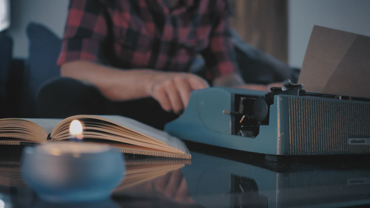 Close-up view of a typewriter while a man works on it - Free Stock Video