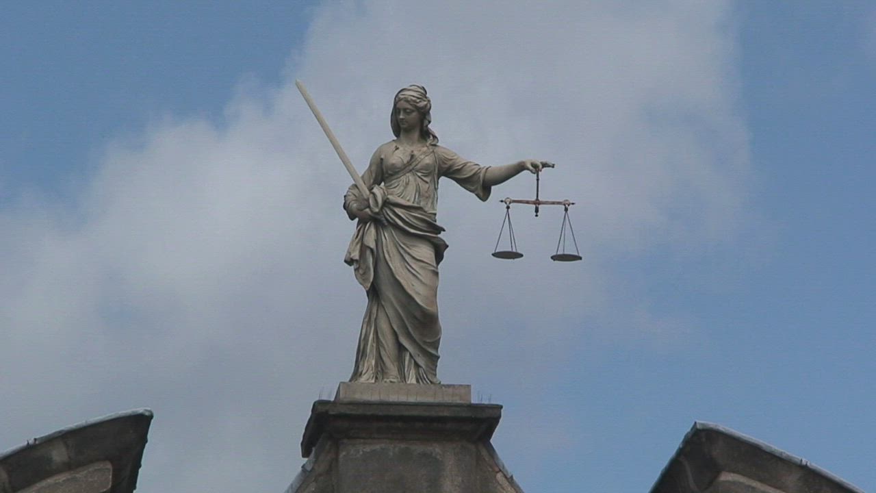 A statue of the scales of justice against the sky