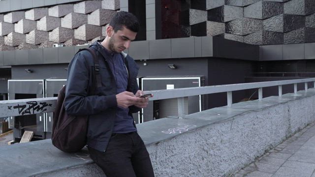 Young man texting in the city.