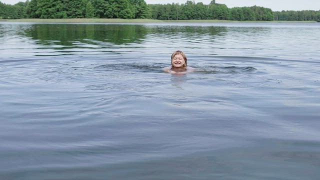 Woman swimming across a lake.