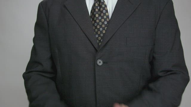 Man in a suit clapping.