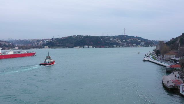 Harbour pilot boat following a cargo ship.