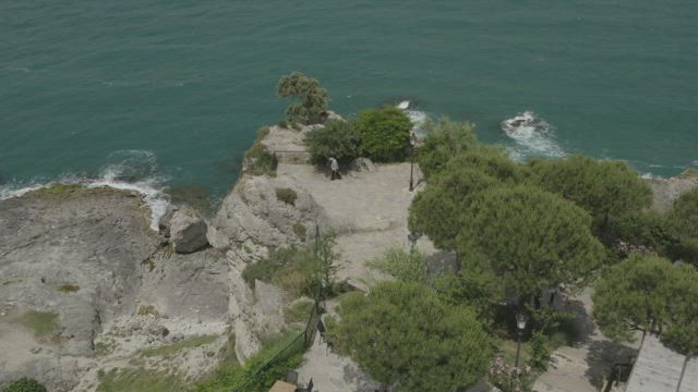 Man looking down over cliffs.