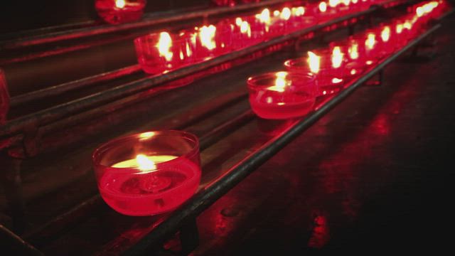 Religious or spiritual place with series of red candles.