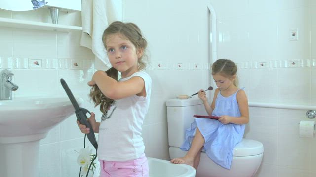 Little girls doing makeup in bathroom.