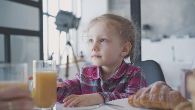 Little girl refuses orange juice for breakfast.