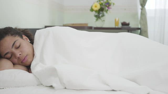 Woman sleeps blissfully through alarm.