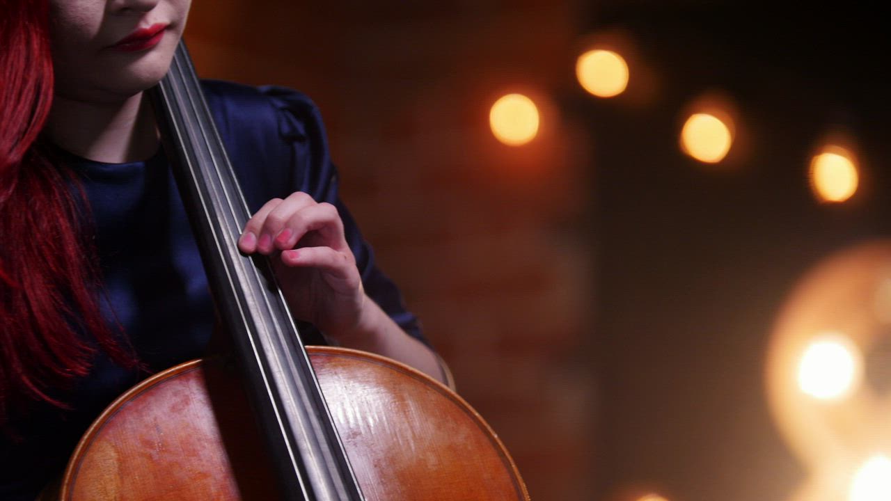 A woman with red hair plays the Cello - Free Stock Video