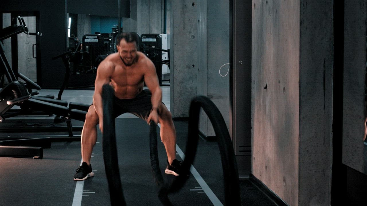 Bodybuilder moving ropes with effort - Free Stock Video