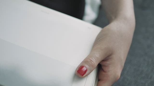 Woman turning pages of a book in close-up shot.