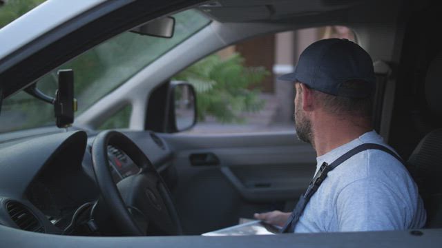 Woman signing for a pizza delivery.