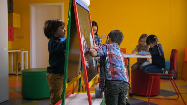 Young boys drawing together.