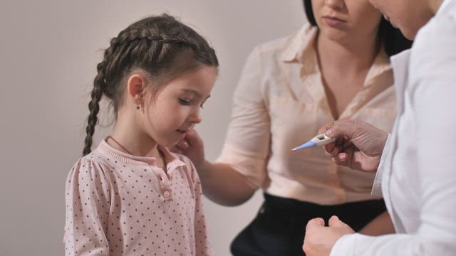 Doctor using a thermometer.