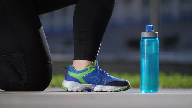 Typing her shoes before exercising.