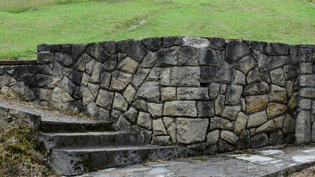 Stone wall with a metal gate.