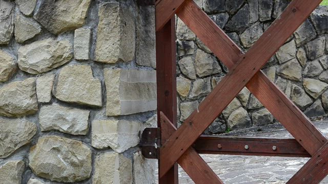 Metal gate against a stone wall.
