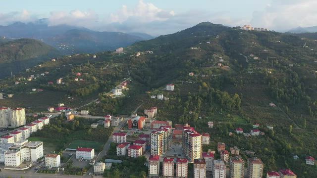 Apartment buildings below a mountain.