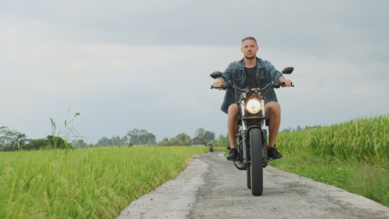 Man rides motorcycle chopper on farm field path - Free Stock Video