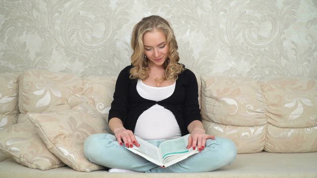 Pregnant woman browsing a book.