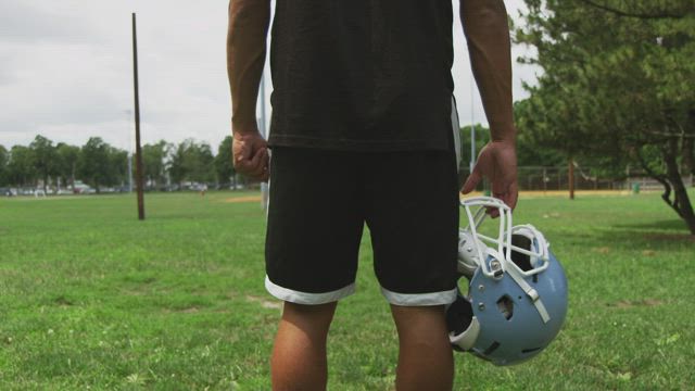 Holding a Football helmet.