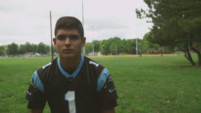 Football player putting on a helmet.