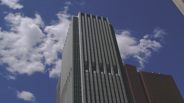 Clouds behind a skyscraper.