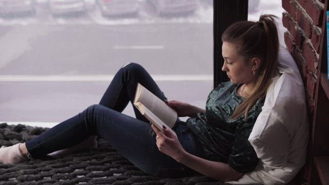 Reading a book in a city apartment.