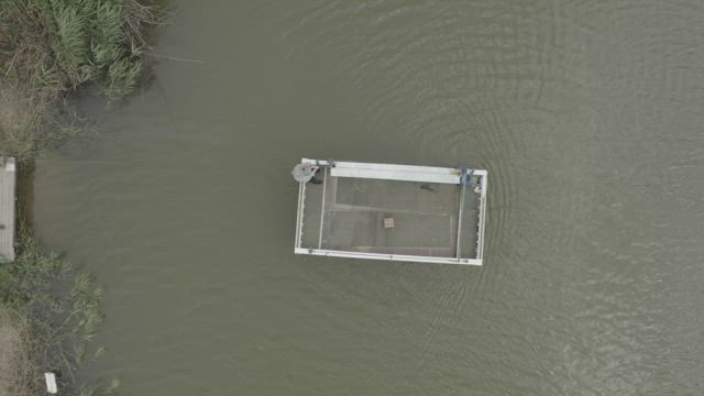 Man taking a raft across a river.