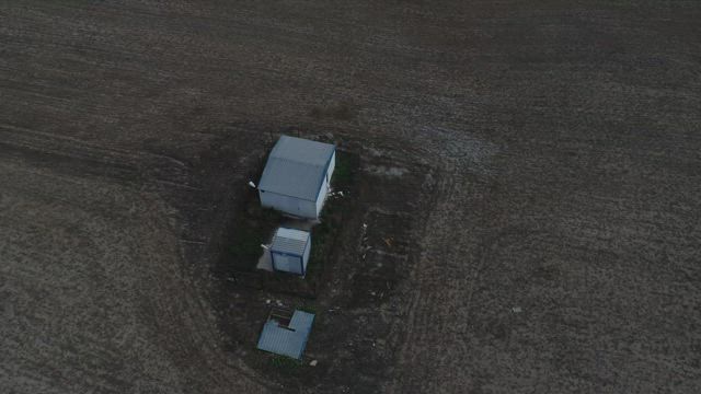 Small cabins in a field.