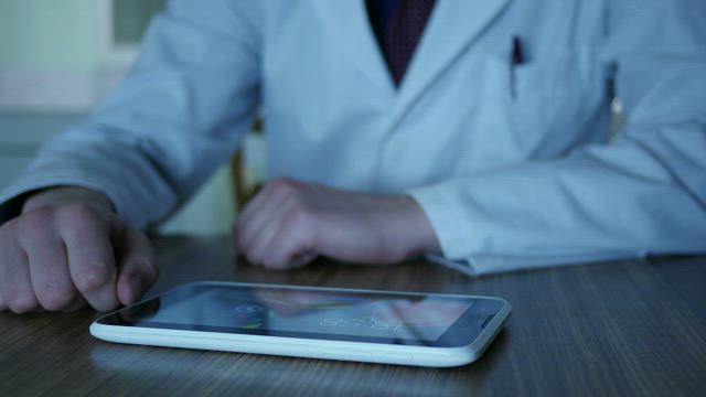 Doctor using a tablet on the desk.