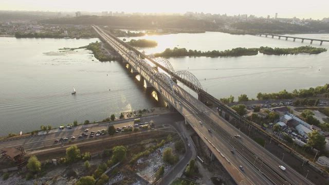 Long bridge with traffic and a river .