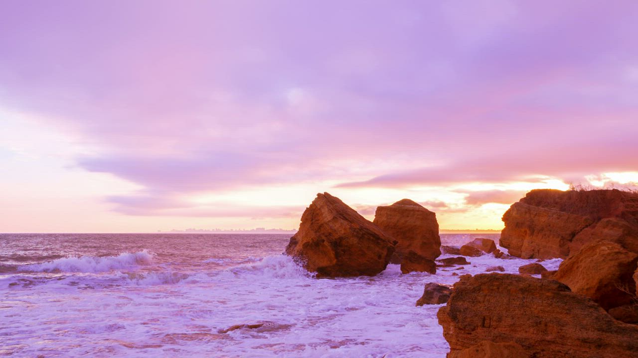 Cloudy sky sunset over the seashore with big rocks - Free Stock Video