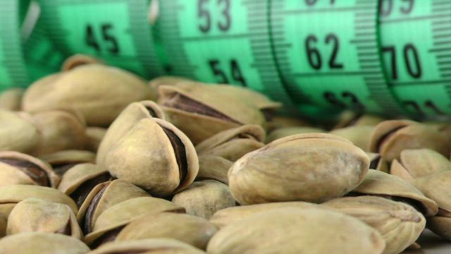 Pistachios and a tape measure, spinning close up.