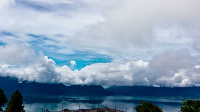 Thick clouds above a still lake.