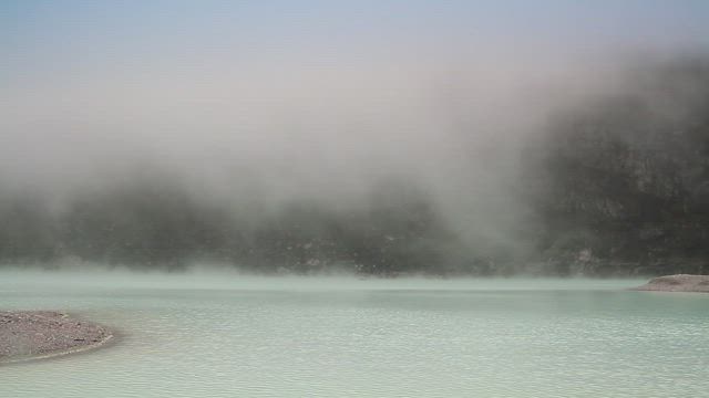 Deep fog descending across a lake.
