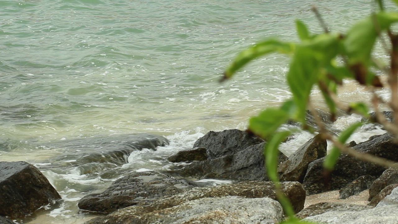 Ocean waters breaking on rocks - Free Stock Video