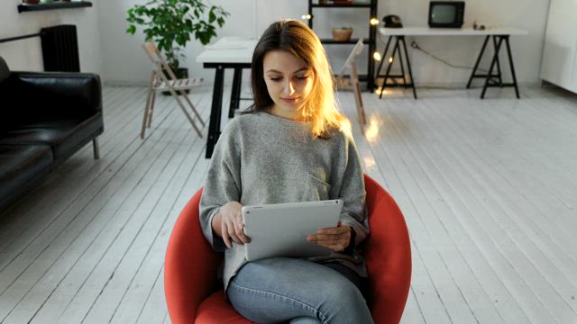 Woman works from her tablet at home.