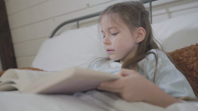 Little girl reads a story in a book.