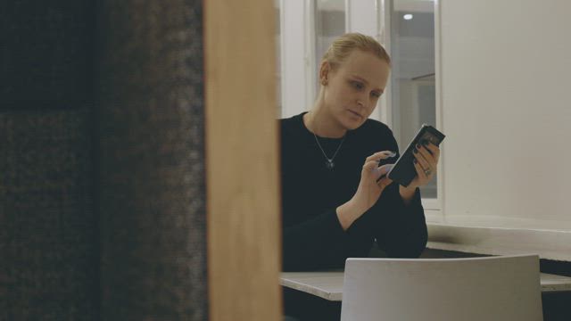 Woman checking her phone in a cafe.